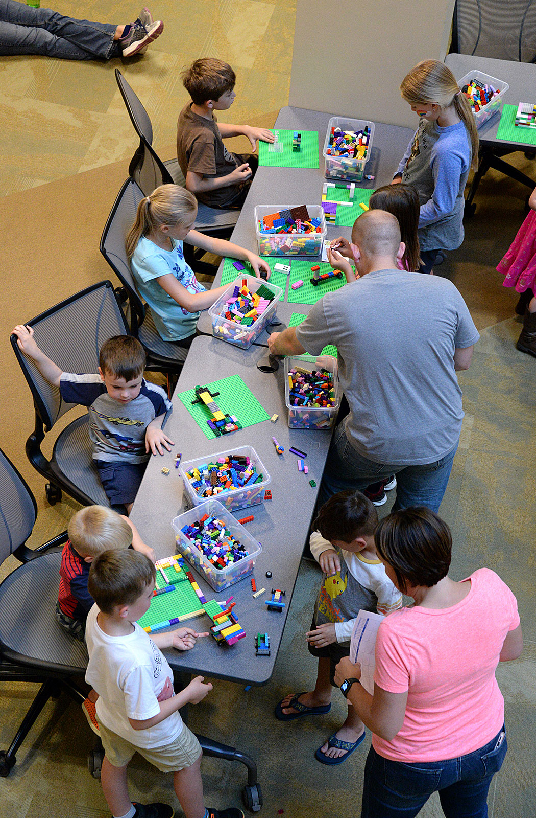 Photo- Children and family members build with Legos at one of the activity stations during the summer reading program kick-off event May 24 at the Combined Arms Research Library.