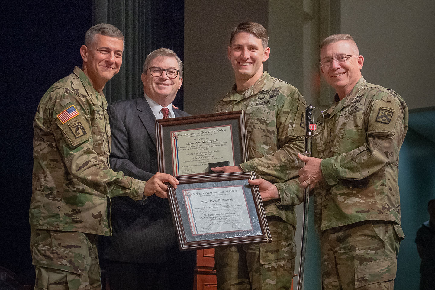 Major Dana M. Gingrich is congratulated by CGSC Commandant Lt. Gen. Michael Lundy (right), Gen. Stephen J. Townsend, Commander TRADOC, and Michael D. Hockley, Civilian Aide to the Secretary of the Army for Kansas and Chairman of the CGSC Foundation upon being named the General George C. Marshall awardee, the top U.S. graduate for the Command and General Staff Officers Class of 2019. Gingrich also received the General George S. Patton Jr. Master Tactician Award, General Douglas MacArthur Military Leadership Writing Award, and the Lt. Col. Boyd McCanna Harris Leadership Award during graduation ceremonies June 14 at Fort Leavenworth's Lewis and Clark Center. (Photo by Dan Neal)