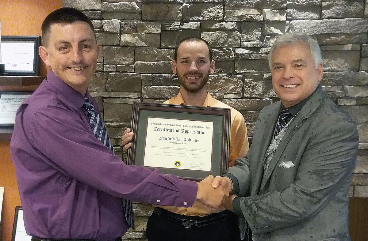 Foundation President/CEO Rod Cox presents a certificate of appreciation to Brian Huntington, left, sales manager for Fairfield Inn and Suites and TownePlace Suites, and Zach Light, center, assistant general manager, on Aug. 26, 2019, in their lobby in Leavenworth, Kansas.