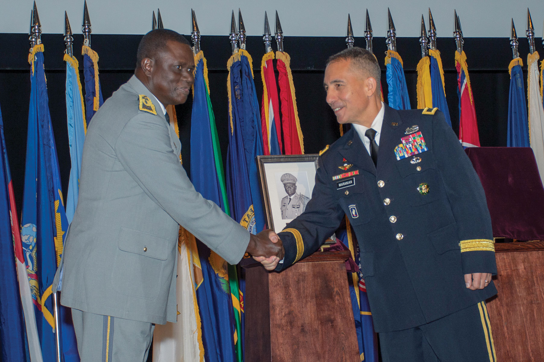 Brig. Gen. Stephen Maranian, CGSC deputy commandant and Army University provost, congratulates Maj. Gen. Francois Ndiaye, chief of staff of the Senegalese Army, after unveiling his IHOF portrait during the induction ceremony Oct. 3, 2019, at the Lewis and Clark Center.