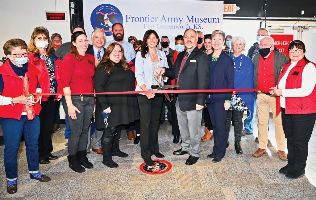 CGSC Foundation Director of Operations Lora Morgan (with scissors, left) and Frontier Army Museum Curator Russell Ronspies (right), flanked by other members of the Foundation, museum and the Leavenworth/Lansing Area Chamber of Commerce, cut the ribbon signifying the CGSC Foundation's opening of operations of the museum's gift shop on Dec. 8, 2021.