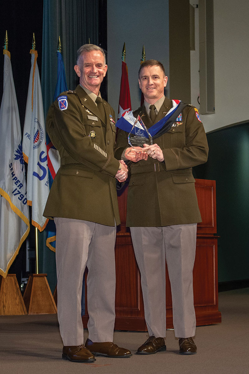 Lt. Col. Colin P. Mahle receives the award for best Advanced Strategic Leader Studies Program monograph from graduation guest speaker Lt. Gen. Walter E. Piatt, Director of the Army Staff, during the SAMS graduation ceremony May 26, 2022.