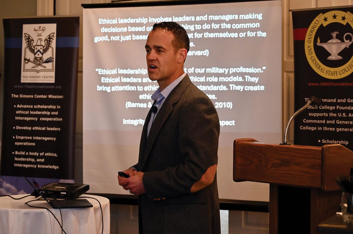 ARNSF JAN w The CGSC Foundation's Simons Center hosted an Arter-Rowland National Security Forum luncheon event on Jan. 15, 2026, at the Carriage Club in Kansas City. The event featured a presentation entitled "Ethical leadership in crisis situations" by Col. Andrew Steadman, director of the Army University Press at Fort Leavenworth, Kansas. The CGSC Foundation's Simons Center Director and ARNSF program leader Col. (Ret.) Todd Schmidt kicked off the Forum welcoming the ARNSF members and their guests. After lunch, he introduced Steadman. Steadman began his presentation by asking the audience when the last time each of them had a serious conversation about ethical leadership and ethical principals and is ethics a part of their daily lives. To help bridge the gap in time that audience members might have discussed ethical leadership he provided some examples, one notably from a 2010 edition of Military Review which read " Ethical leaderships is at the heart of our military profession. Ethical leaders are credible as ethical role models. They bring attention to ethical issues and standards. They create ethical command climates." Steadman added that ethical leadership has many aspects including integrity, honesty, fairness and respect...and also empathy. "Leaders typically come with a dose of empathy and understanding for what consequences come with their decisions," Steadman said. Steadman then went on to describe his responsibilities during his assignment as a military aide to the White House where he and the other military service aides were charged with carrying what has become known as the "nuclear football" and being prepared to assist the president in making a decision to launch nuclear weapons. A decision, Steadman said, that is likely the most ethically challenging one could imagine. He then showed a short clip from the movie House of Dynamite where the fictional president was with his military aide going through that decision process. He talked about his other responsibilities as a White House aide showing photos of his team and other events during that time. He said perhaps the most humbling moments during that assignment was assisting the president with presenting the Medal of Honor four times and having his promotion ceremony to lieutenant colonel conducted in the Oval Office. Steadman said those experiences combined with his experiences in Iraq led him to creating a personal framework for leading through crisis. The first step in his framework is for the leader to set the emotional tone, second, configure the organization for crisis, and finally, define reality. When considering crisis leadership through a moral or ethical lens, Steadman said you should set a tone that not only calms, but guides people though an adherence to some principle or moral code. In configuring or directing the organization during the crisis, leaders should consider ethical bounds that keep them in line. In the flood of information around us, Steadman asked whether we can find ethical leadership. He said we can all find situations where our personal morality should take over and we have to question what things can we change in our lives. He offered a simple model of how we look at the world around us through three lens: the lens of "self" – how we look at the world through our own ideas of moral and ethical grounding; through the lens of the organization or leader we work for or with; and finally through the lens of some higher or broader perspective, possibly a deity. Through these three lens, we can make sense of all the "noise" around us, he said. Steadman provided more examples of ethic situations through movie and news clips, and ultimately challenged the audience with two questions: In what ways might you need to refresh your ethical foundation? As an ethical leader, what does your team need to hear from you? After the presentation and a question and answer period, Schmidt presented Steadman with a small gift in appreciation for his time with the Forum. Steadman also provided information about future ARNSF gatherings.